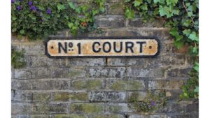 An-original-cast-iron-sign 'No. 1 Court'-picked-out-in-old-crackled-black-and-white-paint .