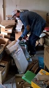 Undaunted, a member of Culvertons house clearance team sorts through the contents of a room - this clearance turned out to be the largest to date - the main bedroom housed the contents of a local stables !