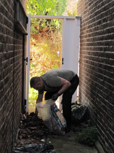 Last job of the day, clearing and tidying the garden outside a property in Richmond upon Thames in Surrey