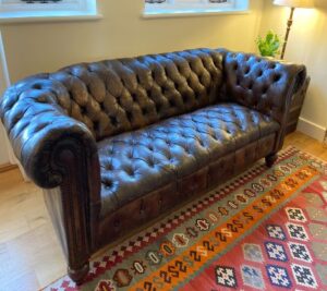 An antique Chesterfield sofa, its once tired and sagging buttoned seat, now totally refurbished.
