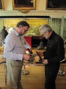 Museum valuation services - whilst  valuing a collection of arms our specialist discusses a pair of duelling pistols with the museum's collection officer.