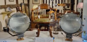 Culvertons shop window display - an impressive pair of wartime floodlights and an antique oak desk chair