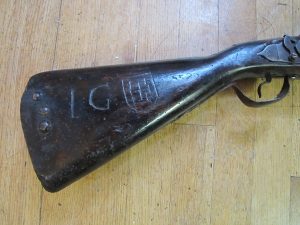 The wooden stock of this antique English dog lock musket has been crudely decorated with what appears to be the arms of Jerusalem (crosses within a shield)