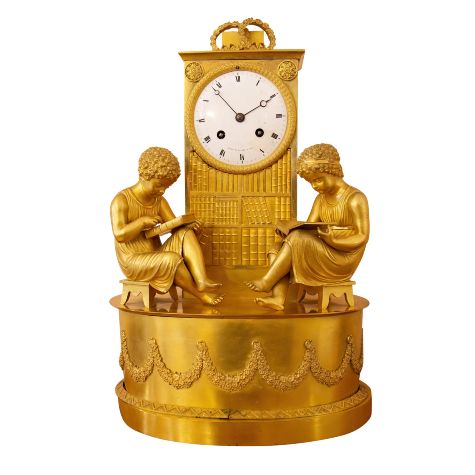 Antique ormolu mantle clocks, like this French Regency example depicting two children reading in front of a bookcase, have declined in value and popularity,