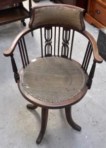 A once elegant, but now neglected piece of Edwardian furniture, this revolving desk chair awaits restoration.